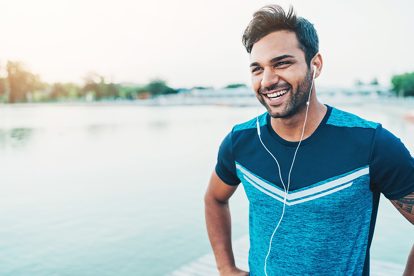 Cheerful young athlete outdoors by the river