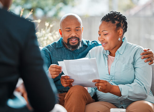 Couple reviewing documents in front of representative