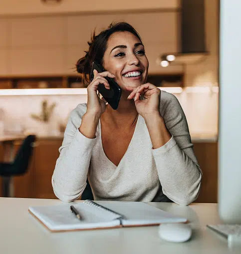 Happy woman on cell phone in kitchen