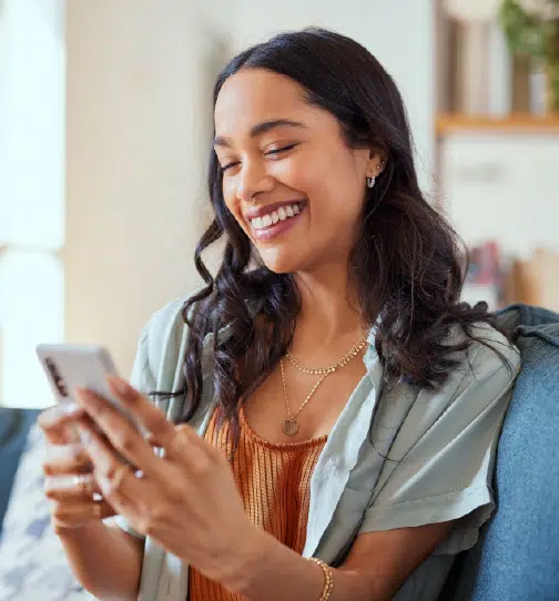 Woman smiling while using smartphone