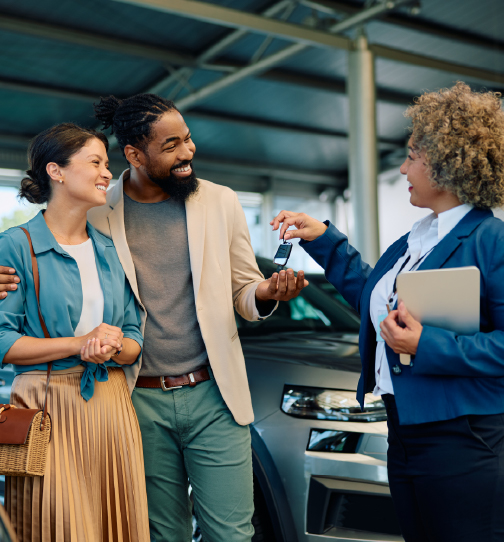 Couple speaking with car salesperson
