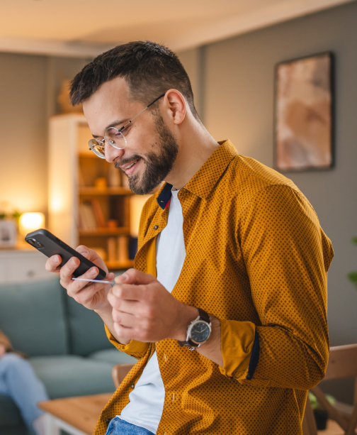 Man smiling while using smartphone