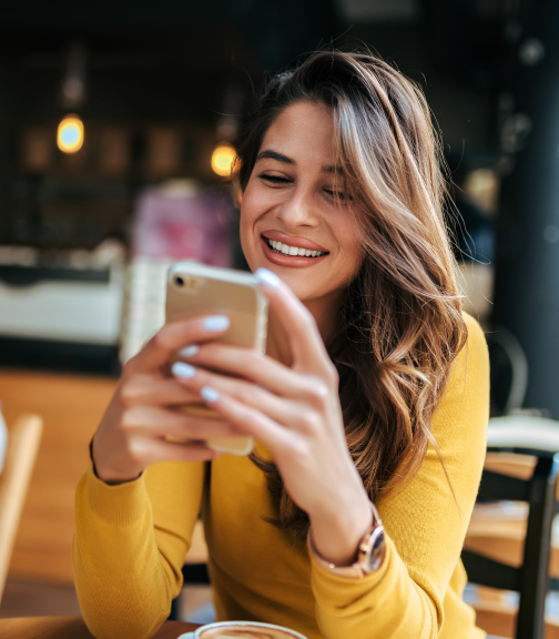 Woman smiling while using smartphone