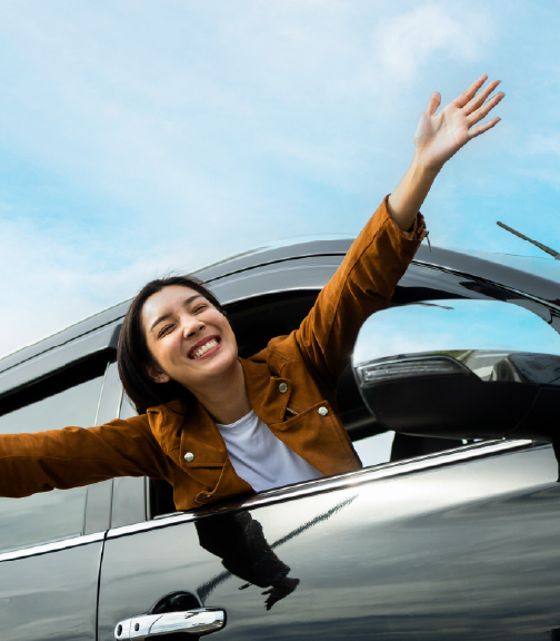 Happy woman with arms outside of car window