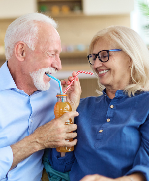 Elderly couple drinking out of straws of same drink