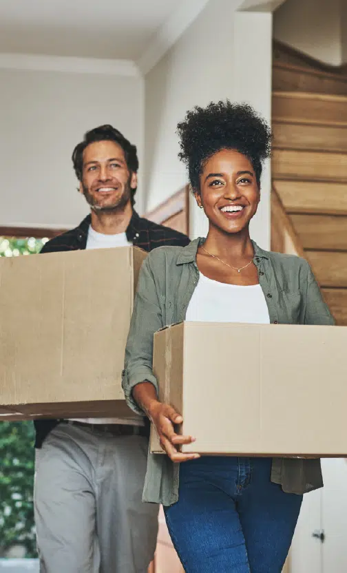 Happy couple holding cardboard boxes