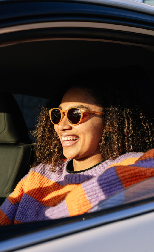 Woman driving car wearing sunglasses