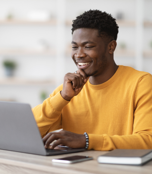 Man smiling while using laptop