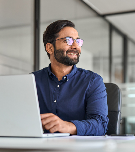 Man smiling while using laptop