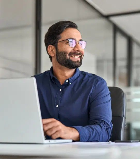 Man smiling while using laptop
