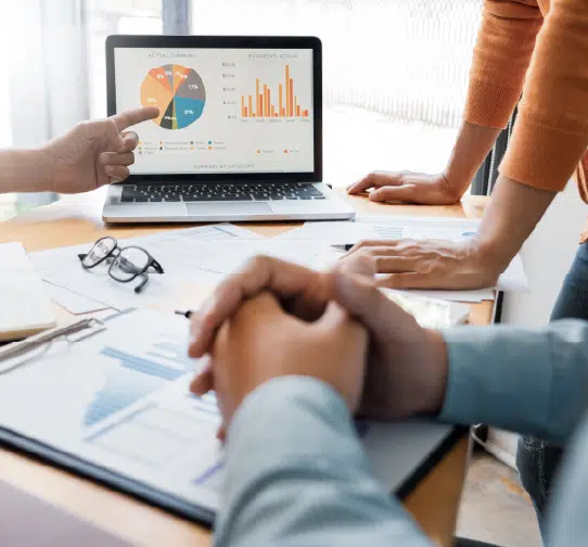 Colleagues reviewing charts on laptop