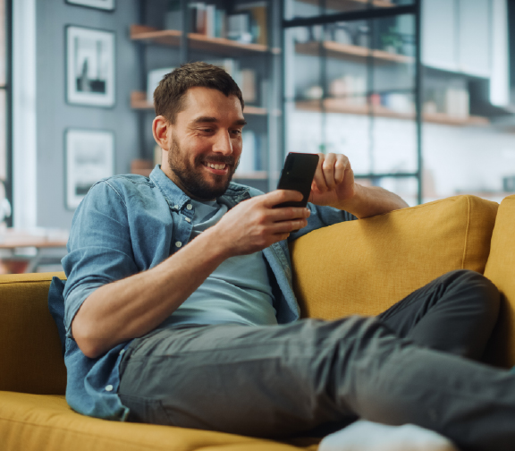 Man relaxing on couch using phone