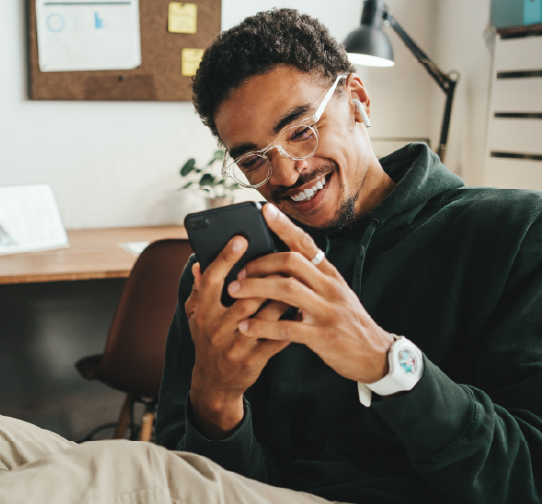 Man smiling while using smartphone