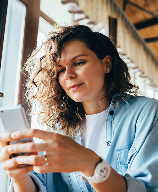Woman smiling while using smartphone